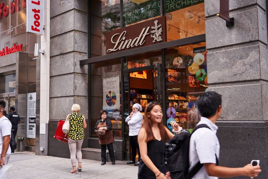 People walk past Lindt Chocolate Shop on 34th Street in New York City.