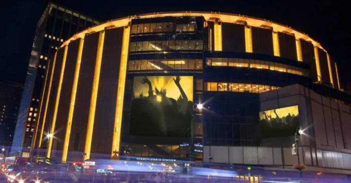 The outside of Madison Square Garden arena, lit up at night.