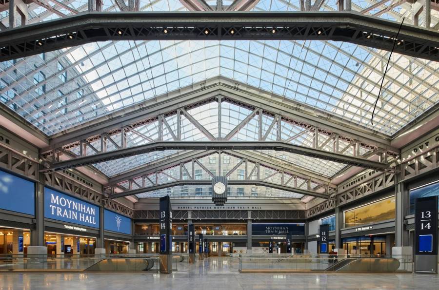 A grand interior view of Moynihan Train Hall, showing off the stations glass ceilings and airy interior.