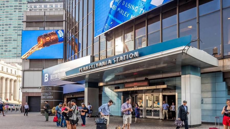 People walk past the entrance of Penn Station in New York City.