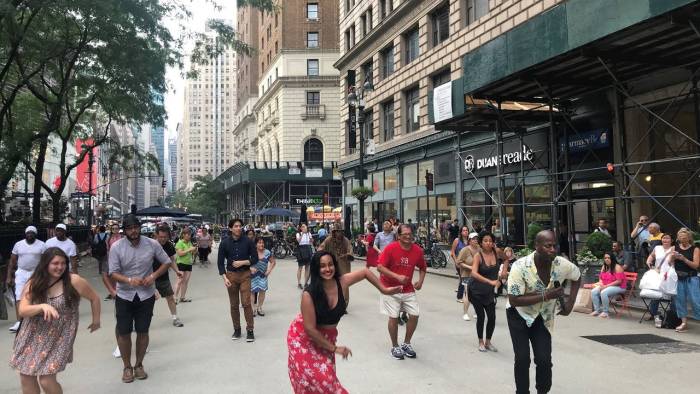 Participants dance outdoors in Greeley Square Plaza in Midtown Manhattan.