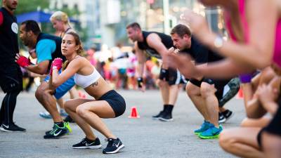 People exercise outdoors at Herald Square Plaza at a free workout class in New York City.